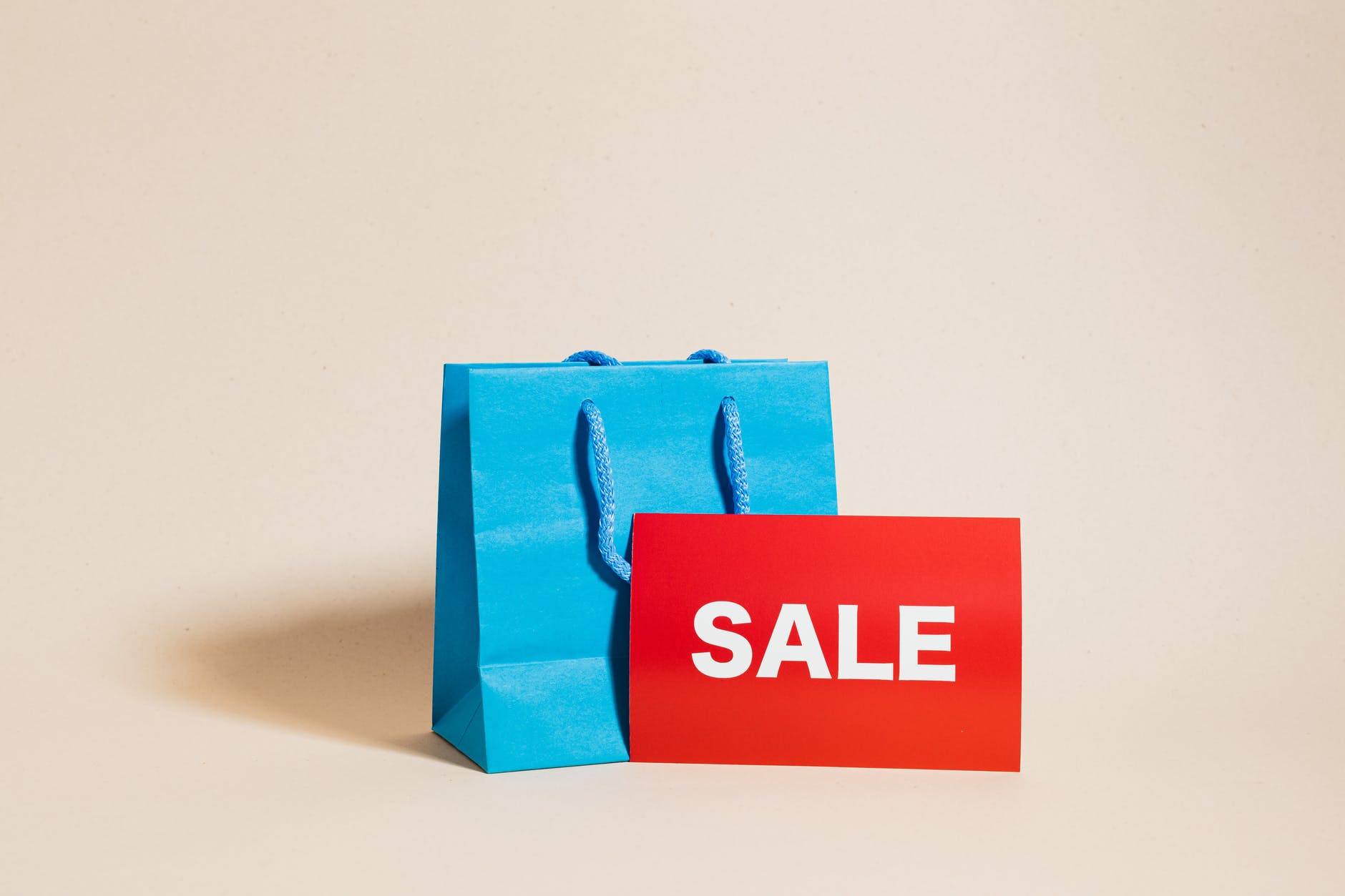 blue shopping bag and a red sale sign
